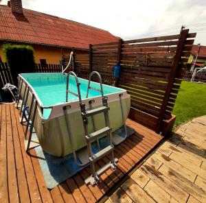 赫拉布斯Drevený raj的浴缸位于围栏旁边的甲板上