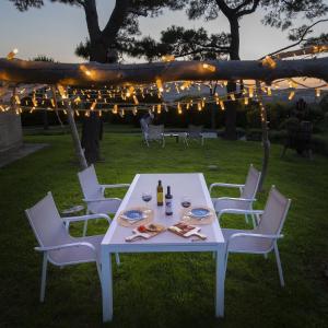 安科纳Il Mandorlo - Agriturismo e Azienda Agricola Ferrato的院子里的白色桌椅,灯光照亮