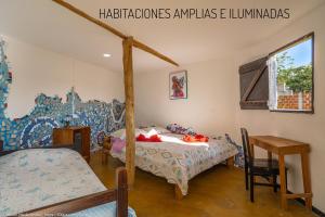 圣奥古斯丁Hostal Bambu的卧室配有1张床、1张桌子和1把椅子
