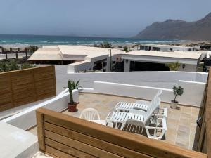 特吉塞Apartment in Famara Beach的阳台配有白色椅子,享有海景。