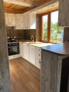 BrailivLe RoSA的厨房配有白色橱柜、水槽和窗户。
