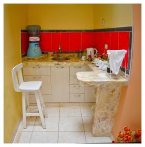 Urbanizacion Buenos AiresHospedaje La Casa Blanca的一间设有红色橱柜和柜台的小厨房