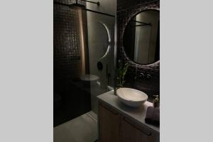 罗兹Apartament Manufaktura z bezpłatnym parkingiem的一间带水槽、淋浴和镜子的浴室