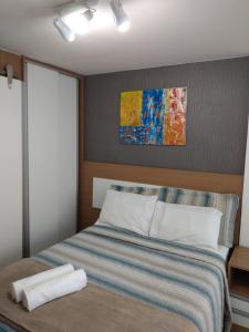 普拉亚多斯卡内罗斯Praia dos Carneiros Flat Hotel Lindo Apto 302的卧室配有一张床,墙上挂有绘画作品