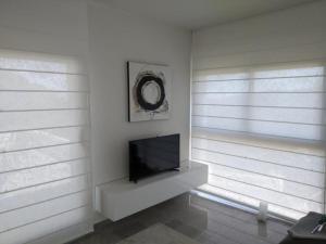巴古尔Villa Es Cau的客厅配有平面电视和2扇窗户。