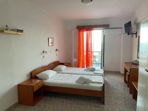 迈萨纳阿波罗公寓的一间卧室配有两张床和橙色窗帘