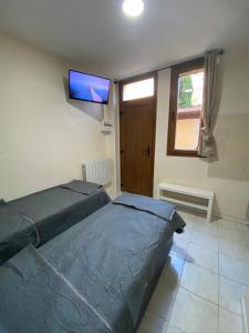 拉加雷讷科隆布RENT APPART - La Garenne Colombes的一间卧室配有一张床和一台平面电视