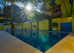 莫罗圣保罗Areia Branca Apart Hotel的游泳池背面有太阳