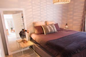 卡尔克湾Spacious and light Kalk Bay Garden Apartment的一间卧室配有一张床和镜子