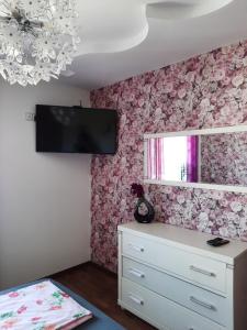 汉诺威Großes Haus Apartement In Laatzen Nähe Messe的卧室配有粉红色花卉壁纸和梳妆台