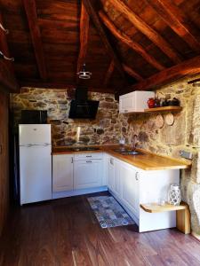 SuarbolEl Cuarto的一间厨房,配有白色家电和石墙