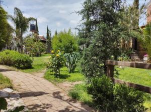 圣胡安特奥蒂瓦坎Temazcal Casa de Barro的一个带栅栏和砖道的花园