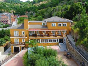 巴尼奥斯德蒙特迈奥尔Hotel Rural El Molino的山前带庭院的黄色房子
