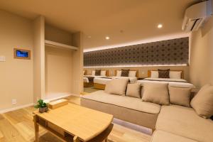长崎GRAND BASE Saiwaimachi的一间带两张床和一张沙发的客厅