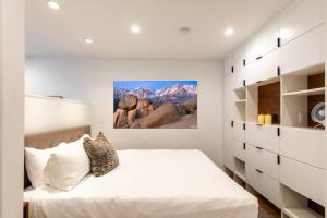 特拉基Modern Hotel-Style Studio - Timber Creek Lodge #210 Hotel Room的一间卧室配有一张带白色墙壁和白色橱柜的床。