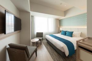 那霸Hewitt Resort Naha的配有一张床和一把椅子的酒店客房