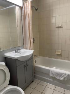 鲍曼维尔自由汽车旅馆的一间带水槽、浴缸和卫生间的浴室