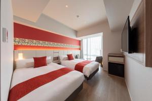 那霸Hewitt Resort Naha的酒店客房设有两张床和一台平面电视。
