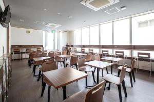 大阪J-SHIP大阪难波客舱胶囊旅馆的一个带桌椅的教室和白色板