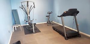 拉克罗斯Norwood Inn & Suites La Crosse的一间带跑步机和椅子的健身房