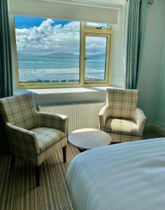 瓦特维尔Seaclusion Luxury Guest Accommodation的酒店客房设有一张床、两把椅子和一扇窗户。