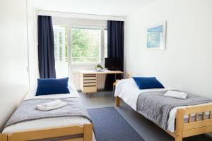 约恩苏ISLO Hostel的一间卧室设有两张床、一张桌子和一个窗口。