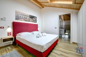 代森扎诺-德尔加达DesenzanoLoft Palazzo Visconti Luxury Suite的一间卧室配有一张大床和红色床头板