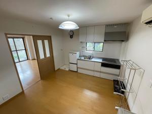 白滨Hotel Isodokei的厨房铺有木地板,配有白色橱柜。