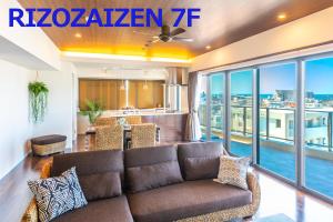 宜野湾市リゾザイゼンホテル的带沙发的客厅和阳台