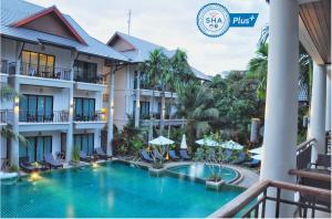 拉威海滩Navatara Phuket Resort - SHA Extra Plus的享有酒店庭院和游泳池的景色