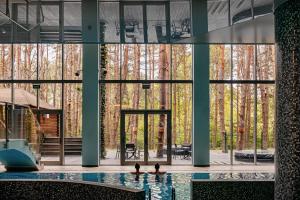 Cedzyna乌洛捷斯科酒店的一座带大窗户的建筑中的游泳池