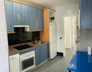 萨莫拉Tunel10的厨房配有蓝色橱柜和白色冰箱