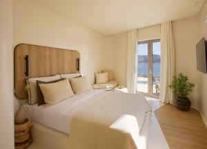 阿波罗尼亚White Pebble Suites的卧室设有一张白色大床和一扇窗户。