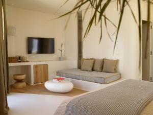 阿波罗尼亚White Pebble Suites的一间卧室设有两张床,墙上配有电视。