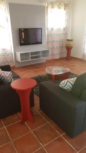 圣菲利佩Hotel Casas do Sol的带沙发和电视的客厅