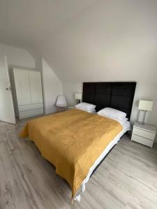 拜罗格拉Bosman Domki的一间卧室配有一张带黄色毯子的大床