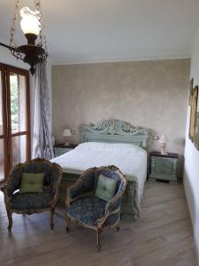 斯特雷萨Nel giardino di Dafne的一间卧室配有一张床和两把椅子