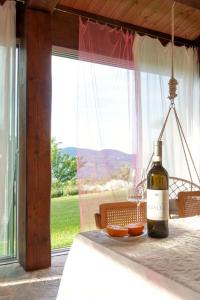 福松布罗内Agriturismo "Le Cannelle" spa & day wellness的窗户前的桌子上坐着一瓶葡萄酒