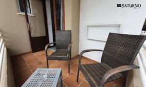 卡拉米洛萨图尔诺酒店的阳台配有2把椅子和1张桌子