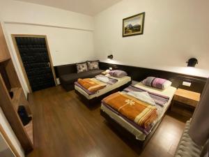 Andrijevica科莫维酒店的一间客房配有两张床和一张沙发
