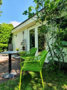 GoirleBed and Breakfast en Studio Het Atelier的两把绿色椅子和一张桌子位于房子前面