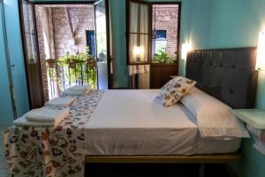 科尔多瓦普尔塔德拉卢纳旅馆的配有2扇窗户的客房内的1张床