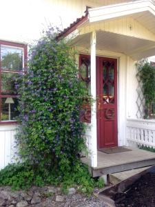 Vintrosa巴克斯住宿加早餐旅馆的红门和紫色花丛的房子