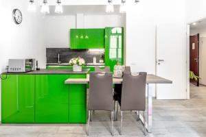 圣雷莫InLuce Apartment Top Class的厨房配有绿色橱柜和桌椅