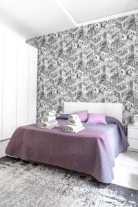 圣雷莫InLuce Apartment Top Class的一间卧室设有紫色的床和黑白墙