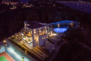 科梅诺Five Stars Villa的享有房子空中景色,晚上有游泳池