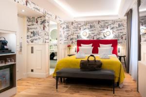 巴黎加蓬酒店的一间卧室配有一张黄色的床和红色床头板