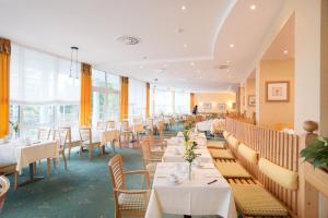 腓特烈罗达腓特烈罗达H+水疗酒店的用餐室设有桌椅和窗户。
