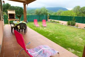 吉索纳恰Locations l'Inzecca的庭院设有红色椅子、桌子和草坪。