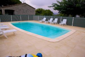 吉索纳恰Locations l'Inzecca的一个带白色椅子的游泳池